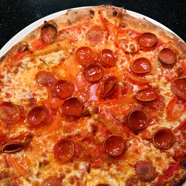 Close-up of a Luna Rossa pepperoni pizza with melted cheese and a crispy crust.