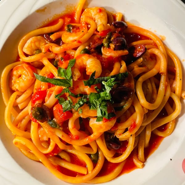 Luna Rossa's Italian pasta dish with shrimp, olives, capers, and basil in a rich tomato sauce.