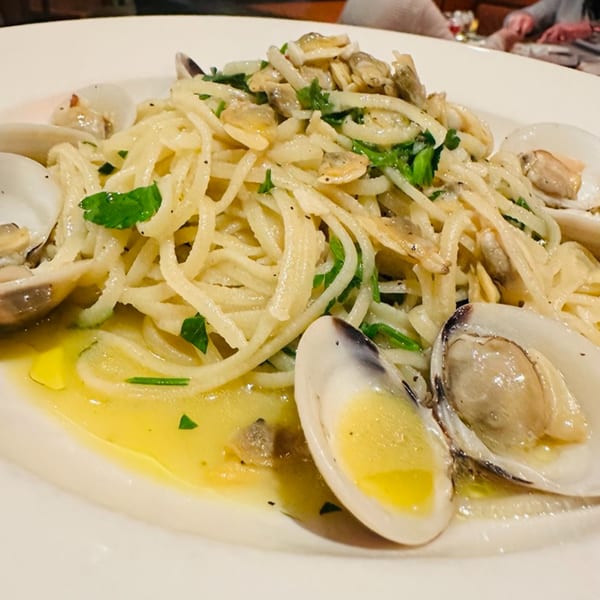 Luna Rossa's linguine alle vongole, featuring pasta, clams, parsley, and olive oil in a white bowl.